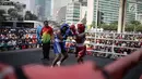 Dua petinju saling melepaskan pukulan pada pertandingan tinju amatir saat Car Free Day di kawasan Bundaran HI, Jakarta, Minggu (29/4). Kegiatan tinju yang diadakan di ruang terbuka tersebut menampilkan 30 partai amatir. (Liputan6.com/Faizal Fanani)