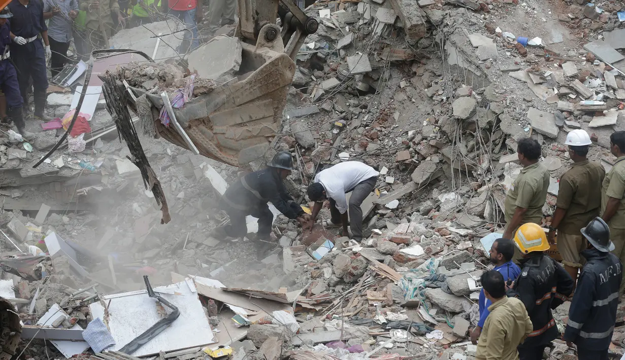 Tim penyelamat mengevakuasi korban akibat runtuhnya gedung lima lantai di Mumbai, India, Selasa (25/7). Sebuah gedung penghunian lima lantai runtuh pada selasa pagi waktu setempat. (AP/Rafiq Maqbool) 