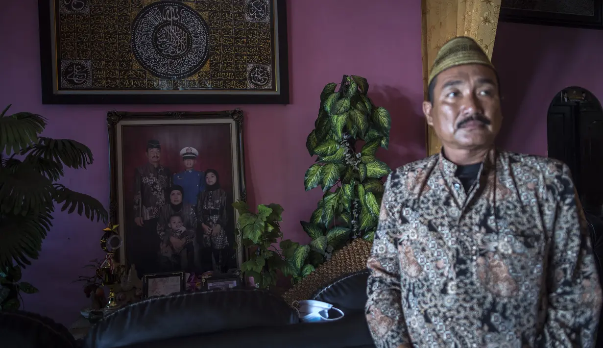 Potret keluarga (kiri) terlihat saat Edy Sujianto berbicara tentang putranya Letnan Satu Muhammad Imam Adi yang bertugas dalam kapal selam KRI Nanggala 402 yang dinyatakan tenggelam, Pasuruan, Jawa Timur, Minggu (25/4/2021). (Juni Kriswanto/AFP)