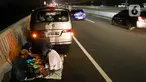 Sejumlah pemudik melaksanakan sahur dan istirahat  di bahu jalan Tol MBZ, Tambun, Kabupaten Bekasi, Jawa Barat, Kamis (20/4/2023). (Liputan6.com/Herman Zakharia)