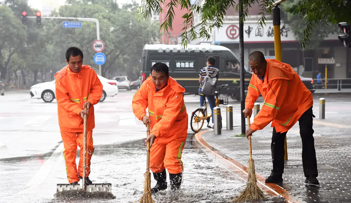 Orang-orang membersihkan genangan air di sebuah jalan di Distrik Haidian, Beijing, ibu kota China (12/8/2020). Badan meteorologi Beijing memperkirakan hujan deras akan mengguyur wilayah Beijing-Tianjin-Hebei antara Rabu (12/8) hingga Kamis (13/8). (Xinhua/Ren Chao)