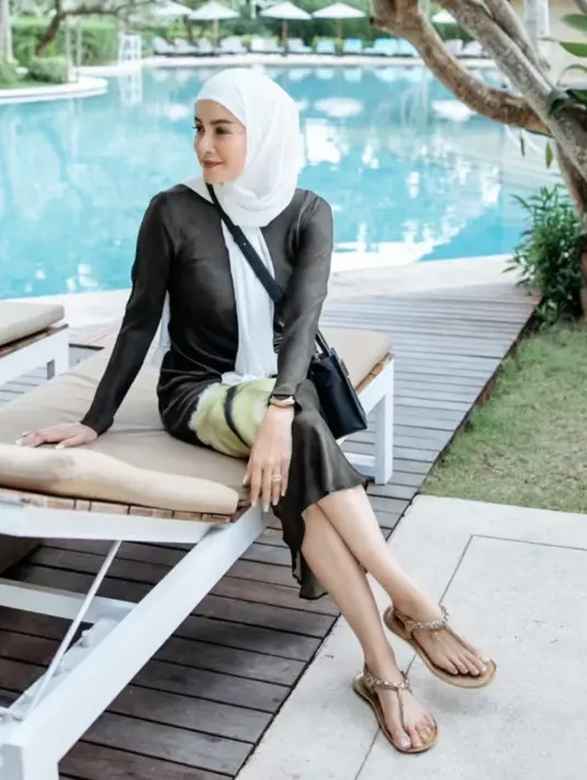 Mengenakan kerudung putih, Olla memadukannya dengan dress hitam salur hijau serta sandalnya. [Instagram/@ollaramlan]