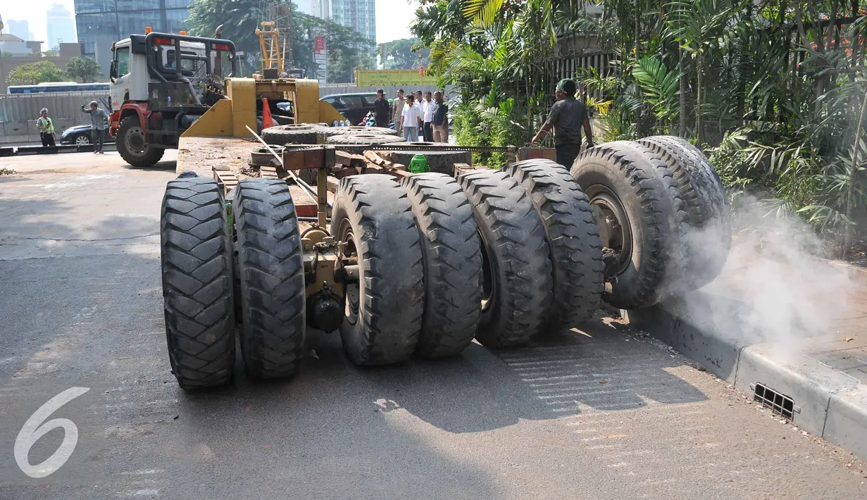 Petugas kepolisian mengatur lalu lintas akibat truk mengalami patah as di Jakarta, Selasa (29/9/2015). Imbas dari truk bermuatan alat berat mengalami patah as itu, Jalan Sudirman mengarah ke Jalan MH Thamrin terpantau padat. (Liputan6.com/Gempur M Surya)