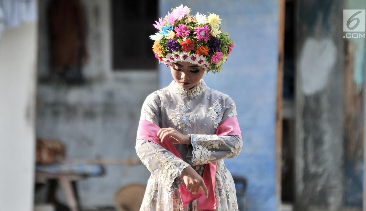 Seorang gadis bersiap mengikuti upacara adat Ngarot di Desa Lelea, Indramayu, Jawa Barat, Rabu (19/12). Tradisi Ngarot merupakan bentuk doa masyarakat Desa Lelea agar hasil tanam padi selalu subur. (Merdeka.com/Iqbal Nugroho)