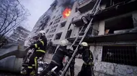 Petugas pemadam kebakaran berusaha mengevakuasi warga dari gedung apartemen yang terkena tembakan di Kyiv, Ukraina (14/3/2022). Dua orang tewas pada 14 Maret 2022 akibat serangan penembakan dan rudal Rusia yang menghancurkan gedung apartemen tersebut. (Ukrainian State Emergency Service via AP)