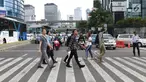 Warga menyebrang jalan Sudirman di kawasan Tosari, Jakarta, Jumat (14/12). Penggunaan pelican crossing di kawasan ini menggantikan fungsi Jembatan Penyebrangan Orang (JPO) Tosari yang akan dibongkar. (Liputan6.com/Helmi Fithriansyah)