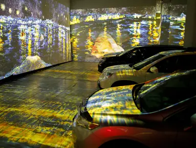 Orang-orang duduk di mobil mereka menikmati pameran seni Vincent Van Gogh di Toronto, Ontario, Kanada pada 3 Juli 2020. Pameran seni di masa pandemi Covid-19 mendatangkan ide kreatif para penyelenggara kegiatan dengan memamerkan hasil karya seni lewat konsep drive-in. (Cole BURSTON/AFP)