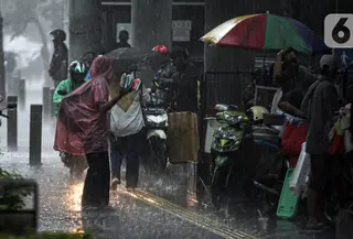 Aktivitas warga saat hujan deras di kawasan Jalan Sudirman, Jakarta, Jumat (9/12/2022). Penjabat Gubernur DKI Jakarta Heru Budi Hartono menyebut pihaknya akan mengkaji penerapan bekerja dari rumah atau work from home (WFH), hal ini berkaitan dengan arahan dari Presiden Joko Widodo atau Jokowi tentang potensi cuaca ekstrem pada penghujung 2022. (Liputan6.com/Faizal Fanani)