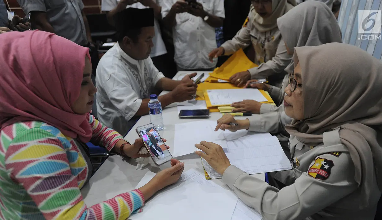 Keluarga korban jatuhnya pesawat Lion Air JT 610 menunjukkan foto kerabatnya saat mendatangi Posko Antemortem di RS Bhayangkara Said Sukanto (RS Polri) Kramat Jati, Jakarta Timur (29/10). (Merdeka.com/Arie Basuki)