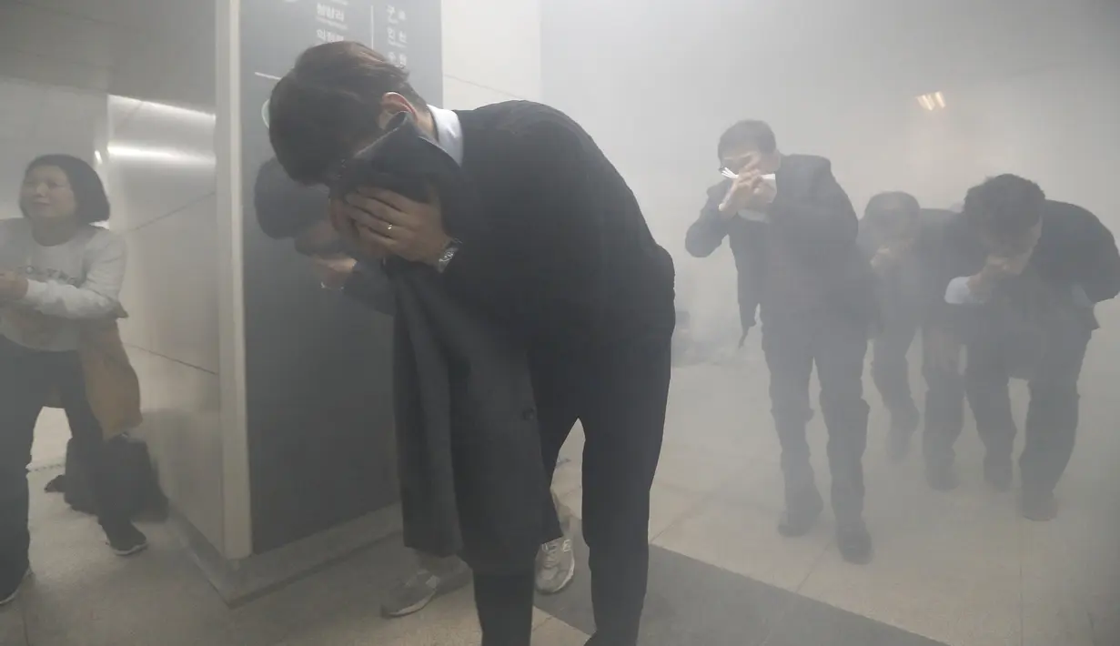 Orang-orang diserang oleh gas tiruan selama latihan anti-terorisme di kereta bawah tanah di stasiun kereta bawah tanah Shindorim di Seoul, Korea Selatan, Selasa 29/10/2019). Latihan anti-terorisme bulan ini dikombinasikan dengan latihan pencegahan bencana. (AP Photo/Ahn Young-joon)