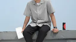 Ini gaya casual pria kelahiran 3 April 2000 yang biasa dipanggil "Ai". Sekadar pakai kemeja abu-abu dan celana hitam, gayanya tetap modis banget. (Liputan6.com/IG/@fadlyfsl_)