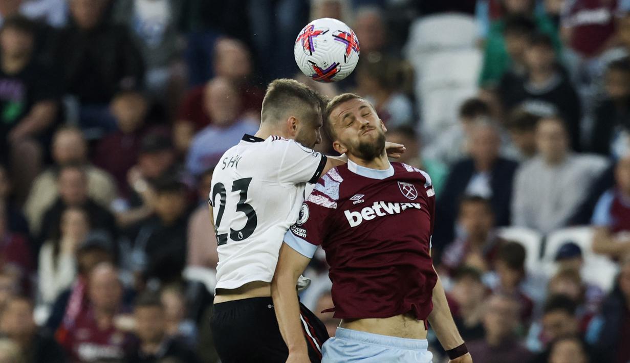 Pemain West Ham United, Tomas Soucek (kanan), berebut bola di udara dengan pemain MU, Luke Shaw, dalam laga pekan ke-35 Premier League 2022/2023 yang berlangsung di London Stadium, Senin (8/5/2023) dini hari. (AFP/Ian Kington)