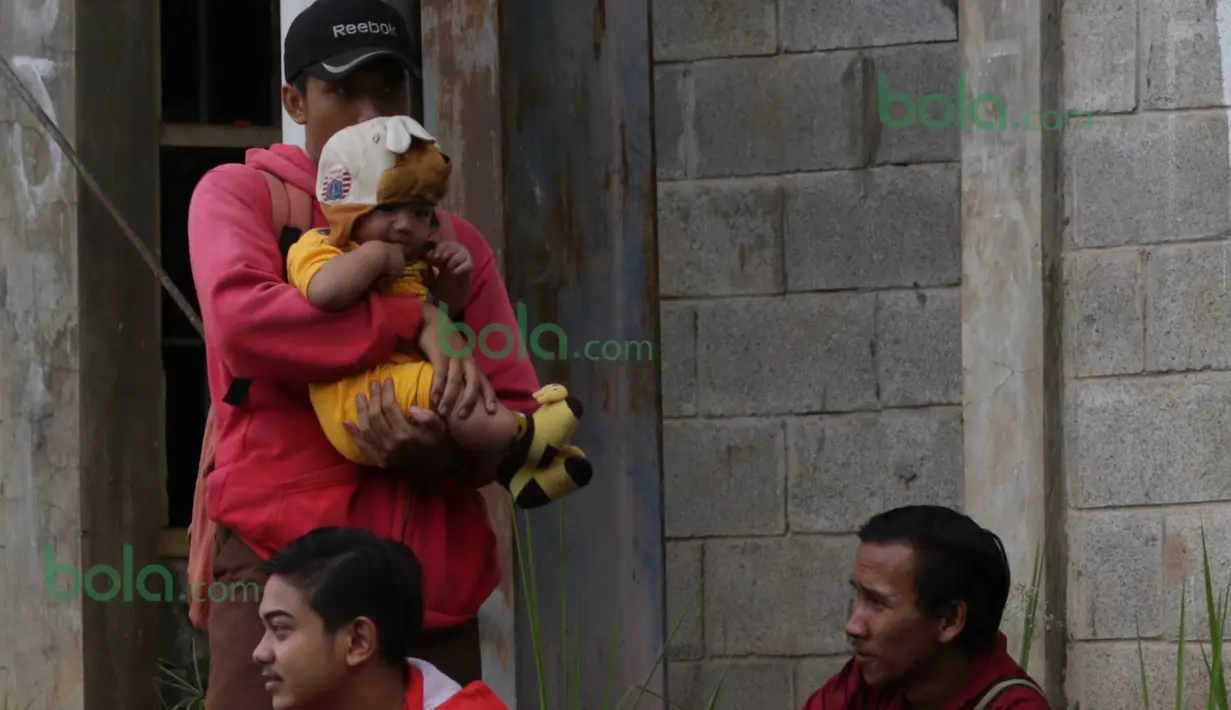 Seorang Suporter The Jack bersama anaknya datang menyaksikan Tim Persija Jakarta berlatih di Lapangan Youth Training Center, Sawanngan, Depok, Rabu (17/2/2016). (Bola.com/Nicklas Hanoatubun)