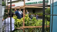 Seng-seng yang menutupi bagian depan gerai Starbucks, Jalan MH Thamrin, Jakarta, mulai dibongkar petugas, Jumat (15/1). Pasca-ledakan, pihak pengelola Menara Cakrawala memagari dengan seng, di sekeliling gedung. (Liputan6.com/Faizal Fanani)