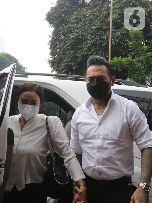 Musikus I Gede Ary Astina alias Jerinx didampingi istrinya, Nora Alexandra, tiba di Polda Metro Jaya, Jakarta, Sabtu (14/08/2021). Kedatangan Jerinx untuk menghadiri proses mediasi dengan pegiat media sosial Adam Deni terkait kasus dugaan pengancaman yang menjeratnya. (Liputan6.com/Herman Zakharia)