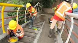Pekerja mengecat jembatan penyeberangan orang (JPO) di kawasan Cipayung, Jakarta Timur, Rabu (30/5). Pengecatan dilakukan untuk merawat JPO agar tidak kusam dan lebih nyaman digunakan oleh pejalan kaki. (Liputan6.com/Immanuel Antonius)