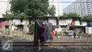 Warga membawa kasur saat alat berat merobohkan bangunan rumah mereka di kawasam Rawajati, Jakarta, Kamis (1/9). Penertiban tersebut menyebabkan warga terpaksa menyelamatkan barang berharga mereka ke tepi rel kereta api. (Liputan6.com/Immanuel Antonius)