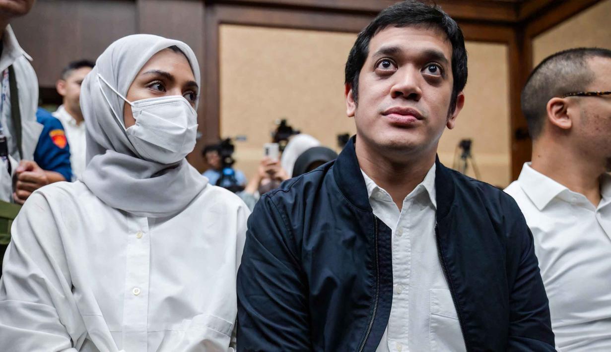 Dalam putusan yang dibacakan pada Jumat 27 Februari dini hari WIB, majelis Hakim menyatakan Muhammad Kerry Adrianto Riza terbukti bersalah dalam perkara korupsi tata kelola minyak mentah dan produk kilang pada PT Pertamina Subholding, dan Kontraktor Kontrak Kerja Sama periode 2018-2023. Tampak dalam foto, mantan Wakil Direktur Optimalisasi Produk di PT Kilang Pertamina Internasional, Muhammad Kerry Adrianto Riza (kanan), yang juga putra pengusaha Riza Chalid, didampingi istrinya Atya Sardadi (kiri), sesaat sebelum mengikuti sidang pembacaan vonis di Pengadilan Tindak Pidana Korupsi, Jakarta, Kamis 26 Februari 2026. (BAY ISMOYO/AFP)
