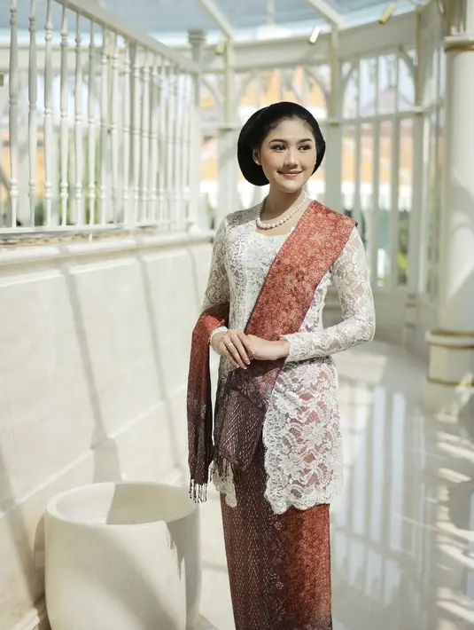Erina Gudono memadukan kebaya putih brokat dengan selendang dan kain warna coklat dan motif serasi. [Instagram/@erinagudono]