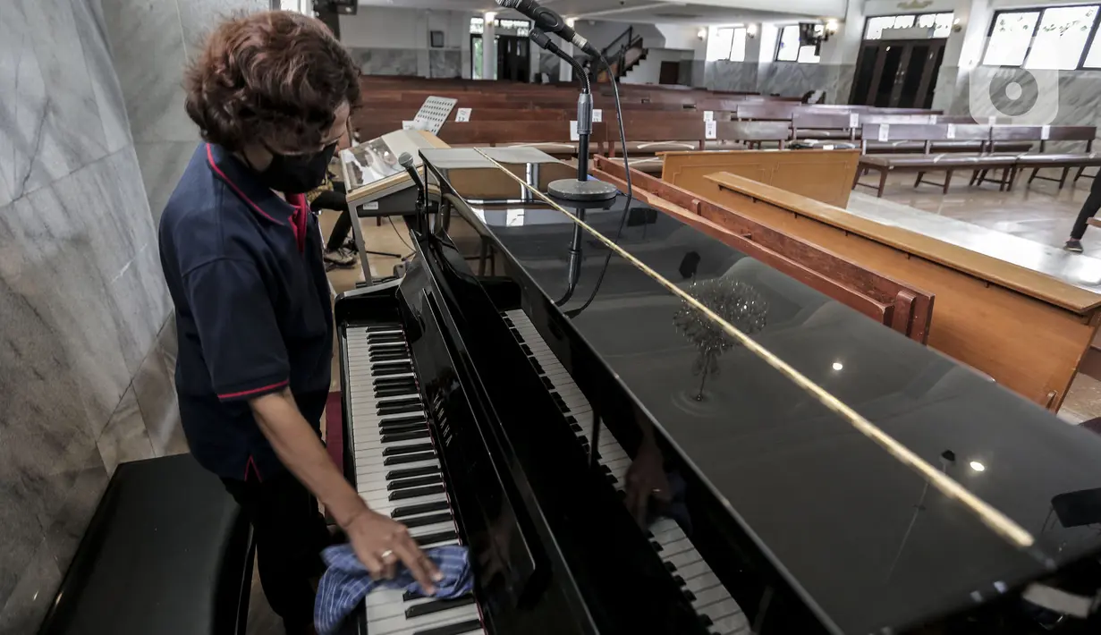 Karyawan membersihkan piano untuk menyambut kenormalan baru di Gereja Protestan Indonesia Bagian Barat (GPIB) Effatha, Jakarta, Sabtu (4/7/2020). GPIB Effatha menerapkan protokol kesehatan seiring kembali dibukanya gereja tersebut untuk ibadah di tengah pandemi COVID-19. (Liputan6.com/Johan Tallo)