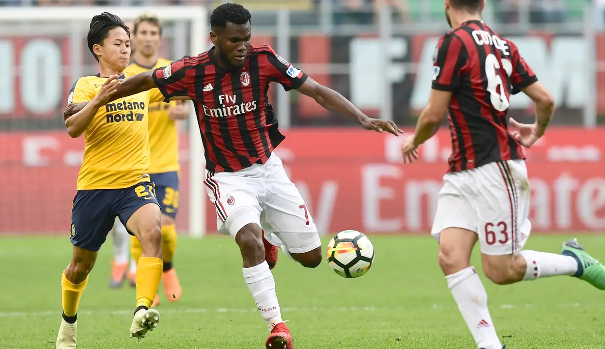 Pemain AC Milan, Franck Kessie (tengah) melepaskan tembakan saat di adang pemain Hellas Verona, Seung-Woo Lee (kiri) pada lanjutan Serie A di San Siro stadium, Milan, (5/5/2018). AC Milan menang telak 4-1. (AFP/Miguel Medina)