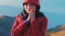Saat mendaki Gunung Prau, gadis yang berusia 22 tahun ini tidak lupa untuk berfoto dengan pemandangan indah pegunungan. Gayanya tampak imut dengan jaket berwarna merah dan topi dengan warna senada. (Liputan6.com/IG/@arafahrianti)