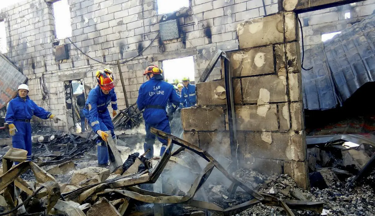 Petugas memeriksa puing-puing sebuah gedung yang hangus terbakar di desa dekat Kiev, Ukraina, Minggu (29/5). Sedikitnya 17 orang tewas orang tewas setelah kebakaran yang menghanguskan sebuah gedung yang digunakan sebagai panti jompo. (REUTERS)