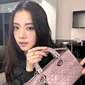 Jisoo BLACKPINK tampil kasual dengan atasan hitam dengan tas Dior Small Lady D-Joy berwarna peony pink. [Dior].