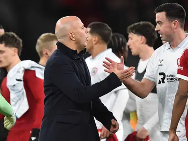 Pelatih Liverpool asal Belanda, Arne Slot berjabat tangan dengan bek Barnsley asal Irlandia, Eoghan O'Connell usai pertandingan putaran ketiga Piala FA Inggris di Stadion Anfield, pada Senin 12 Januari 2026 waktu setempat atau Selasa (13/1/2026) dini hari WIB. The Reds, tim besutan Arne Slot, sukses menyudahi perlawanan sengit Barnsley dengan skor akhir 4-1. (PETER POWELL/AFP)