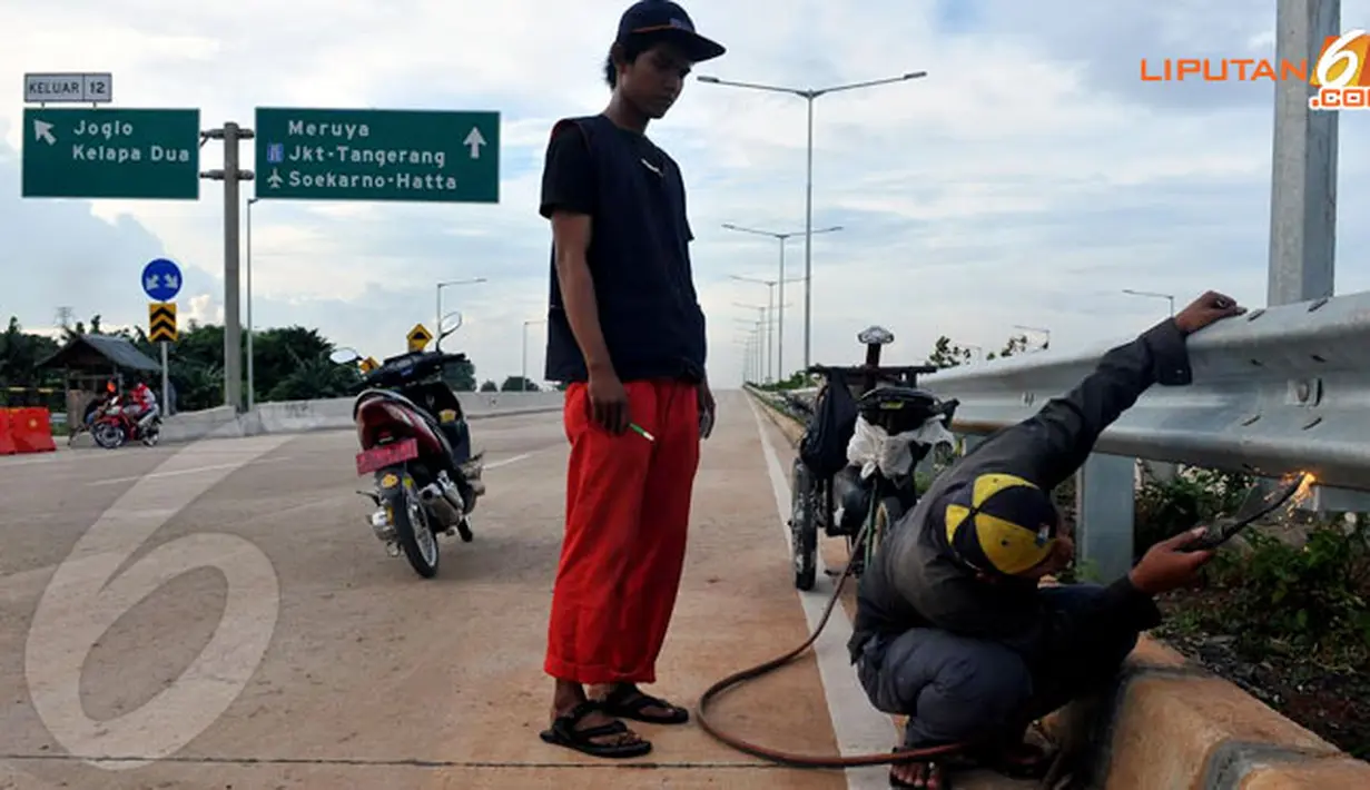 Petugas juga tampak merapihkan sambungan besi pembatas tol (Liputan6.com/Johan Tallo) 