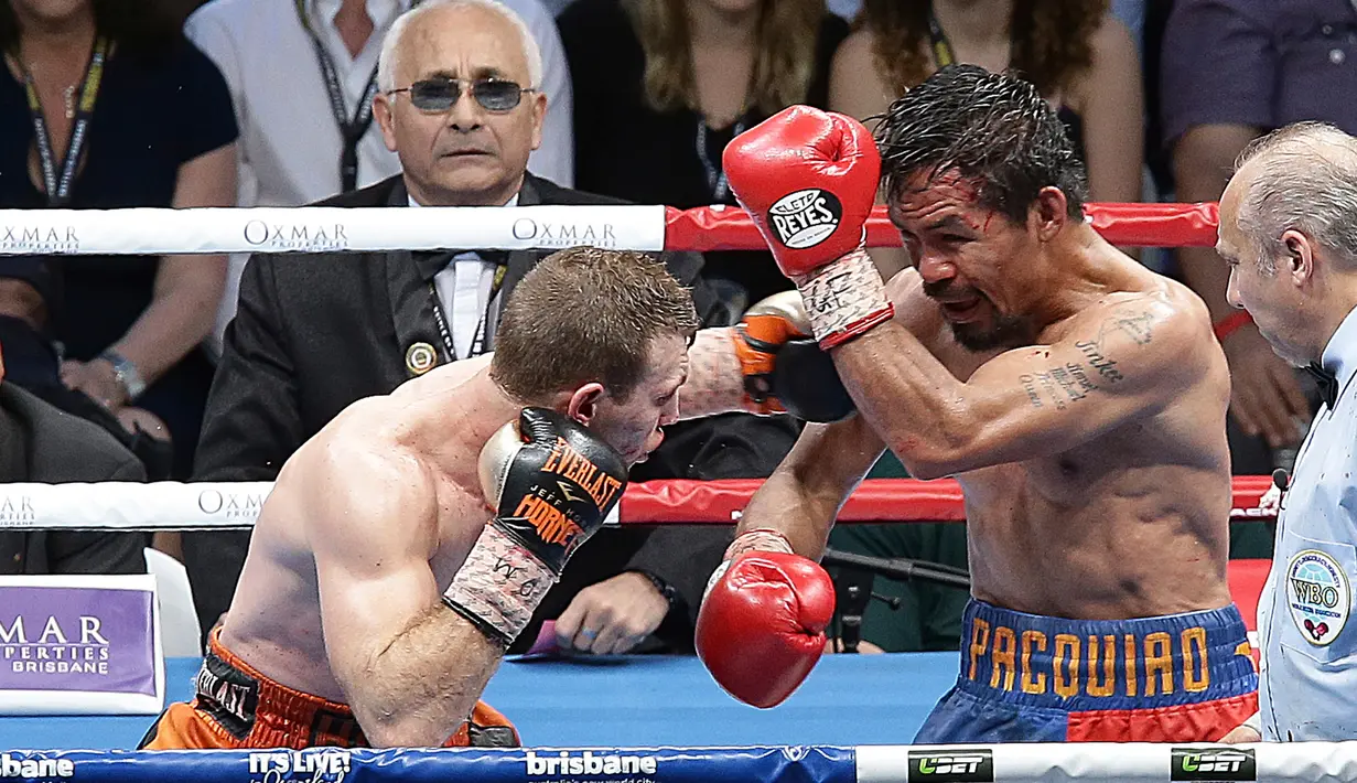 Petinju Filipina, Manny Pacquiao, menangkis pukulan petinju Australia, Jeff Horn pada perebutan sabuk juara kelas welter versi WBO di Stadion Suncorp, Brisbane, Minggu (2/7). Horn mengalahkan Pacquiao dalam pertarungan 12 ronde. (AP/Tertius Pickard)
