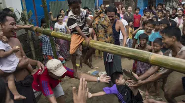 Seorang bocah terjatuh saat mengikuti Perang Bantal di Yangon, Rabu (4/1). Acara tersebut digelar dalam rangka HUT Kemerdekaan Myanmar ke-69. (AFP PHOTO / YE AUNG THU)