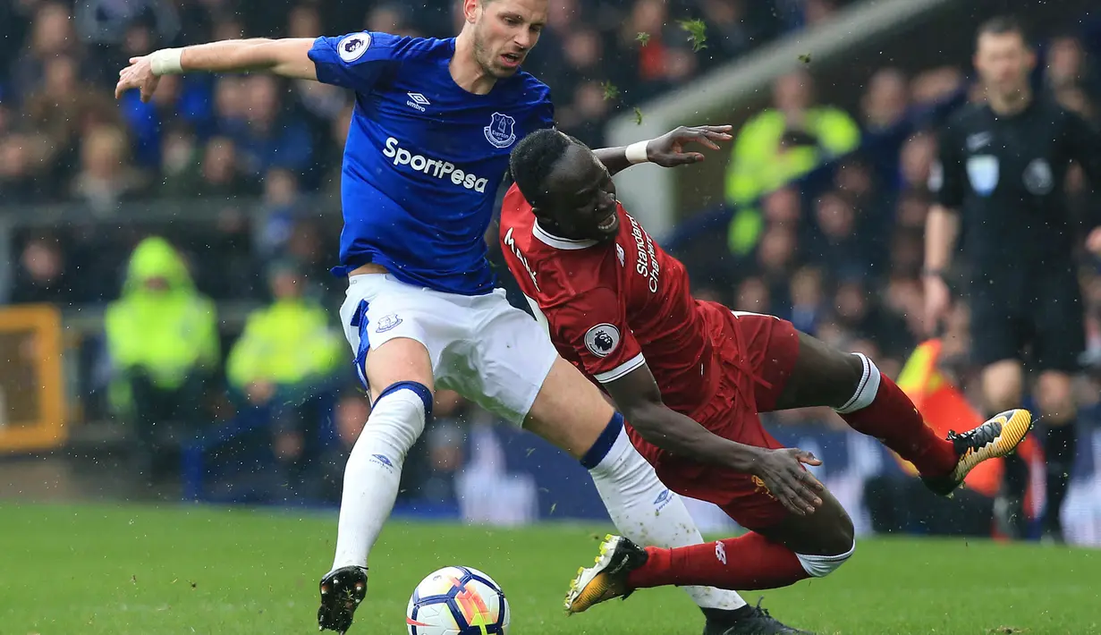 Gelandang Everton, Morgan Schneiderlin, menjatuhkan gelandang Liverpool, Sadio Mane, pada laga Premier League di Stadion Goodison Park, Liverpool, Sabtu (7/5/2018). Kedua klub bermain imbang 0-0. (AFP/Lindsey Parnaby)