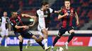 Penyerang Juventus, Paulo Dybala, berusaha melewati pemain Bologna pada laga Serie A di Stadion Renato Dall'Ara, Senin (22/6/2020). Juventus menang 2-0 atas Bologna. (AP/Massimo Paolone)