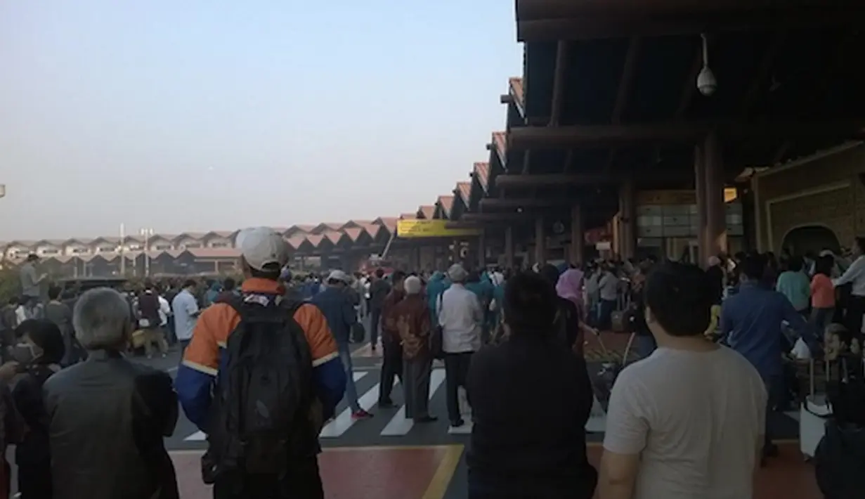Sejumlah penumpang melihat kebakaran yang terjadi di Terminal 2E di Bandara Soekarno Hatta, Jakarta, Minggu (5/7/2015).  Kebakaran di Terminal 2E ini membuat panik ribuan penumpang yang sedang menunggu jadwal penerbangan. (Twitter@thisisyudhis)