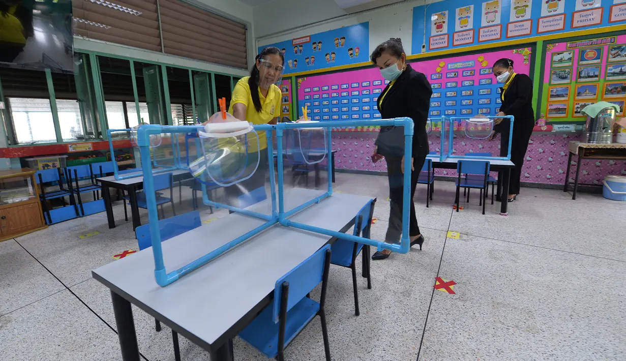 Para guru memeriksa lembaran plastik dan pelindung wajah yang digunakan untuk membantu mencegah penyebaran COVID-19 di sebuah sekolah di Bangkok, Thailand, Selasa (23/6/2020). Sejumlah sekolah di Thailand dijadwalkan akan dibuka kembali pada 1 Juli mendatang. (Xinhua/Rachen Sageamsak)