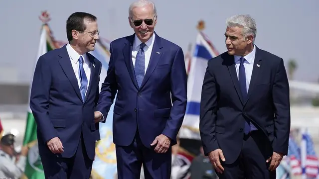 Presiden Joe Biden berdiri bersama Perdana Menteri Israel Yair Lapid (kanan) dan Presiden Isaac Herzog (kiri) setelah tiba di Bandara Ben Gurion, Rabu, 13 Juli 2022, di Tel Aviv. (Foto AP/Evan Vucci)