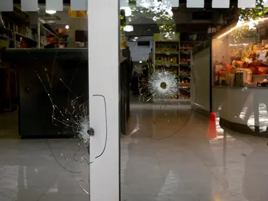 Lubang peluru memecahkan jendela supermarket Unico, jaringan toko kelontong milik mertua pemain sepak bola Lionel Messi, di Rosario, Argentina, 2 Maret 2023. Dua orang yang mengendarai sepeda motor dilaporkan menembaki toko tersebut. (AP Photo/Sebastian Lopez Brach)