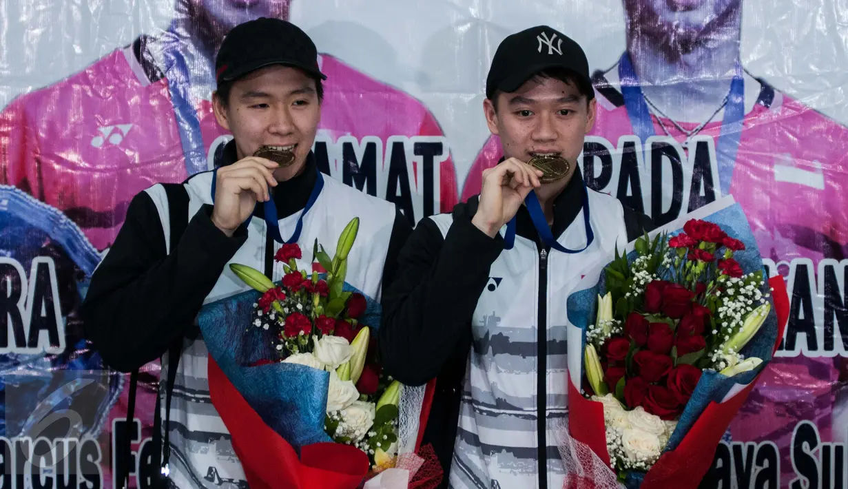 Kevin Sanjaya Sukamuljo dan Marcus Fernaldi Gideon memamerkan medalinya saat tiba di Bandara Internasional Soekarno Hatta, Tangerang, Banten, Selasa (14/3). Kevin dan Marcus adalah juara ganda putra All England 2017. (Liputan6.com/Gempur M Surya)