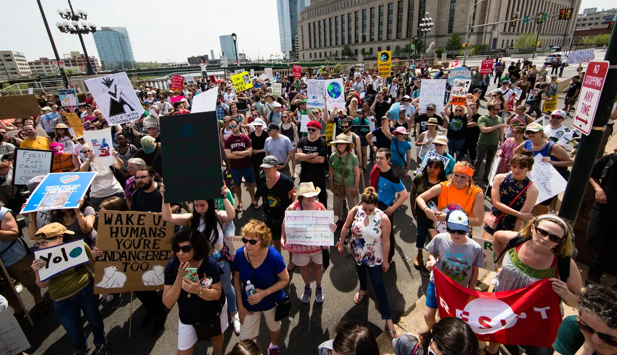 Sejumlah orang melakukan demonstrasi bertepatan 100 hari kerja Trump sebagai presiden di Market Street di Philadelphia, AS, Sabtu (29/4). Demonstran memprotes kebijakan Presiden Donald Trump terkait perubahan iklim. (AP Photo / Matt Rourke)