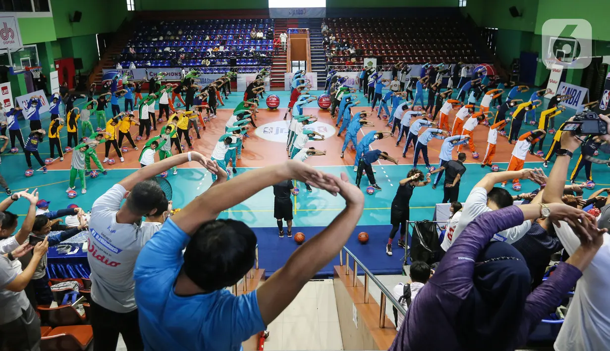 Siswa siswi Madrasah melakukan pemanasan sebelum mengikuti teknik dasar bola basket di GOR Bulungan Jakarta, Selasa (31/05/2022). Program Jr. NBA Coaches Academy diikuti oleh 450 guru dari Madrasah ditujukan bagi guru dan pelatih olahraga di Madrasah yang fokus pada keterampilan dan pelatihan basket, serta memberikan edukasi terkait kurikulum yang dapat diimplementasikan di sekolah. (Liputan6.com/Fery Pradolo)