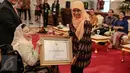 Mensos Khofifah memberikan piagam penghargaan kepada Sinta Nuriyah Wahid saat menghadiri acara peringatan Hari Disabilitas Internasional 2015 di Istana Negara, Jakarta, Kamis (3/12/2015). (Liputan6.com/Faizal Fanani)