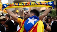 Seorang pria bersorak ketika Parlemen Catalonia mendeklarasikan kemerdekaan dari Spanyol di luar gedung parlemen di Barcelona, Jumat (27/10). Sejumlah pendukung kemerdekaan, turun ke jalan dan menyanyikan lagu tradisional Catalan. (AP/Emilio Morenatti)