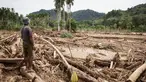 Seorang pria melihat kerusakan yang disebabkan oleh banjir yang membawa sisa-sisa pembalakan liar di Pelangai Gadang, Sumatera Barat, pada Sabtu 15 Maret 2025. (REZAN SOLEH/AFP)