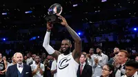 Pemain tim LeBron James, LeBron James mengangkat tropi usai timnya mengalahkan tim Stephen dalam pertandingan basket NBA All Star di Los Angeles, Amerika Serikat, Minggu (18/2). Tim LeBron menang dengan skor 148-145. (AP Photo/Chris Pizzello)