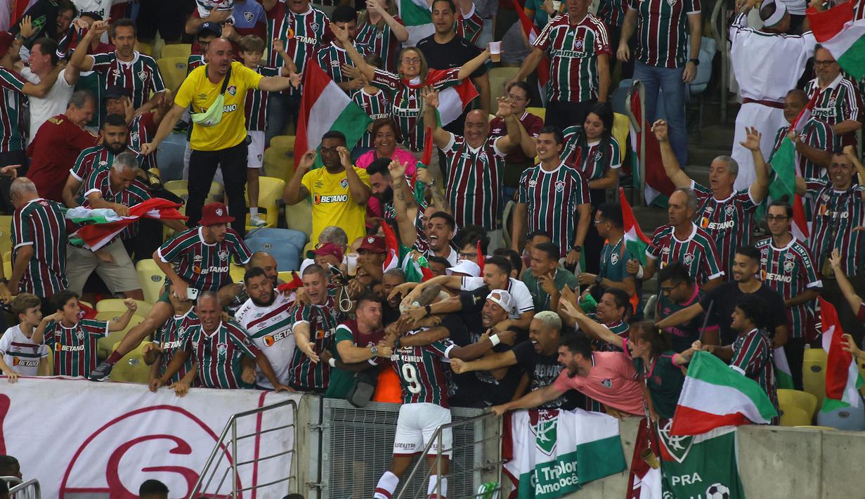 Pemain Fluminense, John Kennedy melakukan selebrasi bersama para pendukung timnya setelah mencetak gol ke gawang Boca Juniors pada final Copa Libertadores yang berlangsung di Maracana Stadium , Rio de Janeiro, Brasil, 5 November 2023 WIB. (AFP/Silvio Avila)