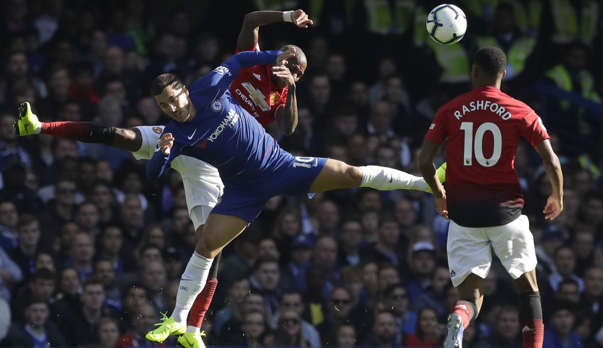 Penyerang Chelsea, Eden Hazard, duel udara dengan gelandang Manchester United, Ashley Young, pada laga Premier League di Stadion Stamford Bridge, Sabtu (20/10/2018). Kedua tim bermain imbang 2-2. (AP/Matt Dunham)