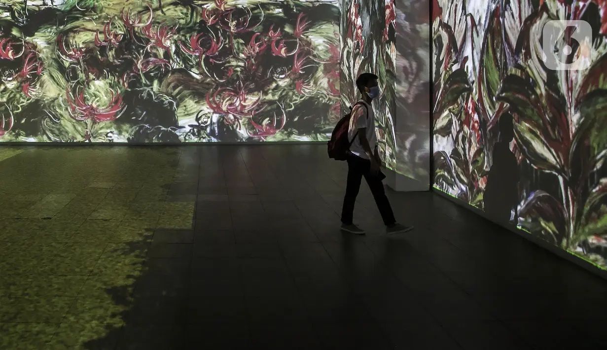 Pengunjung melihat karya proyeksi video mapping di pameran imersif Affandi: Alam, Ruang, Manusia di Galeri Nasional Indonesia, Jakarta, Rabu (28/10/2020). Pengunjung yang melihat pameran harus melakukan protokol kesehatan dan dibatasi hanya 20 penonton per sesi kunjungan. (Liputan6.com/Johan Tallo)