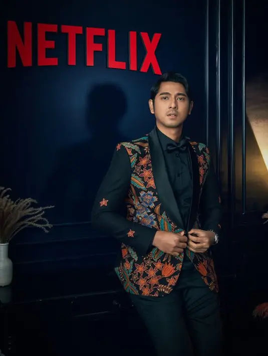 Arya Saloka tampil menawan dengan jas hitam beraksen batik dari Wong Hang Tailor lengkap dengan inner kemeja dan dasi kupu-kupunya, dipadukan celana hitamnya. [@netflixid]