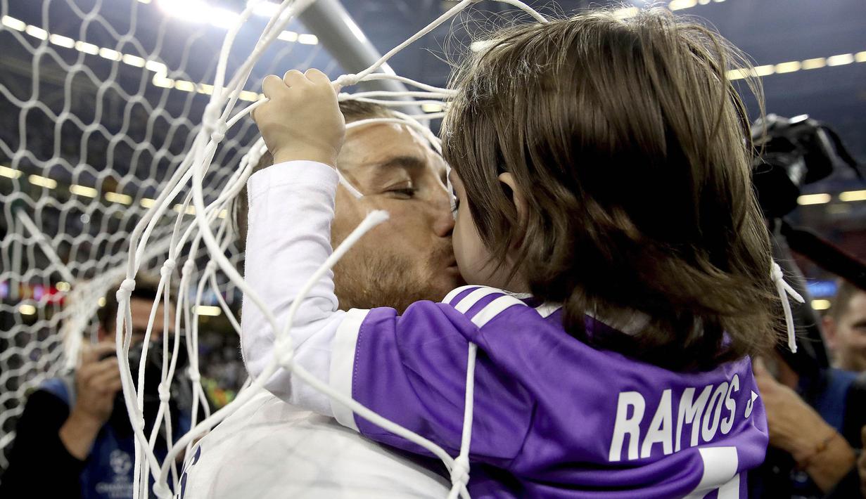 Kapten Real Madrid, Sergio Ramos, merayakan kemenangan dengan mencium anaknya setelah memenangkan final Liga Champions dengan mengalahkan Juventus 4-1  di Stadion Millennium, Cardiff, (03/06/2017).(AP/Nick Potts)